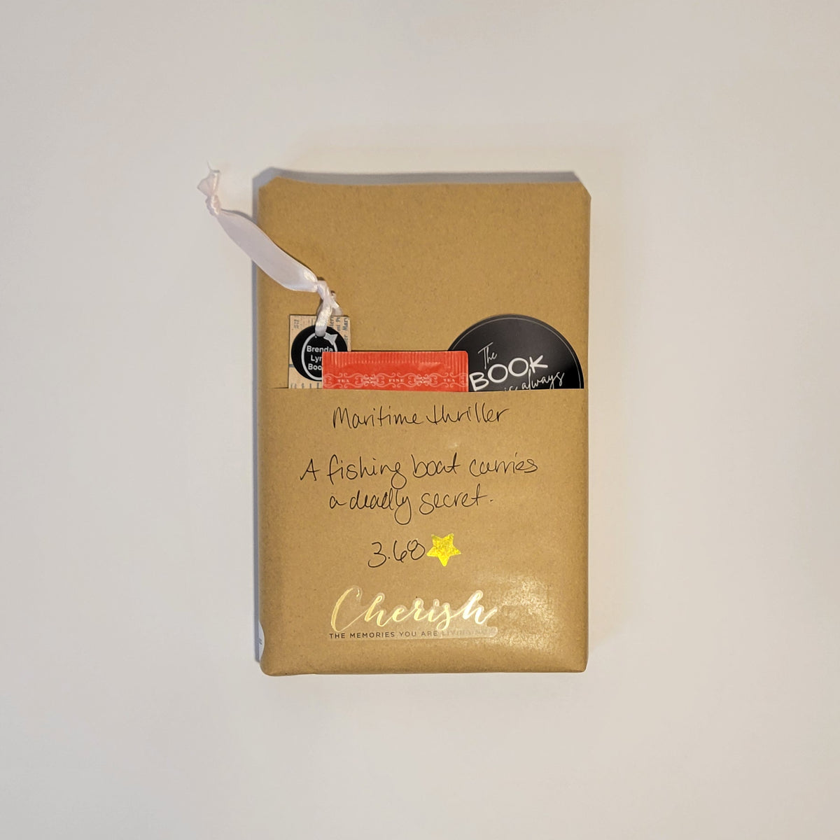Hardcover book wrapped in brown paper with writing on it and goodies tucked inside.