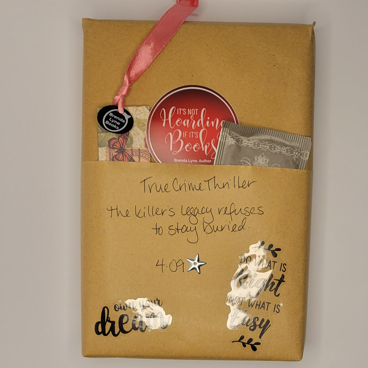 Paperback book wrapped in brown paper with writing on it and goodies tucked inside.