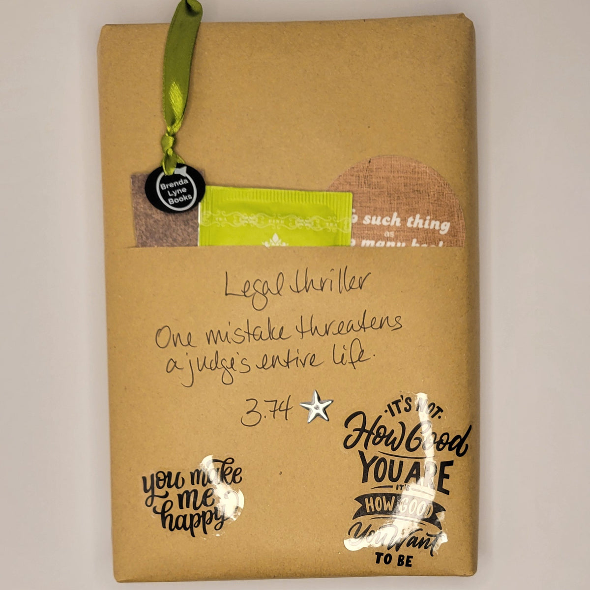 Hardcover book wrapped in brown paper with writing on it and goodies tucked inside.