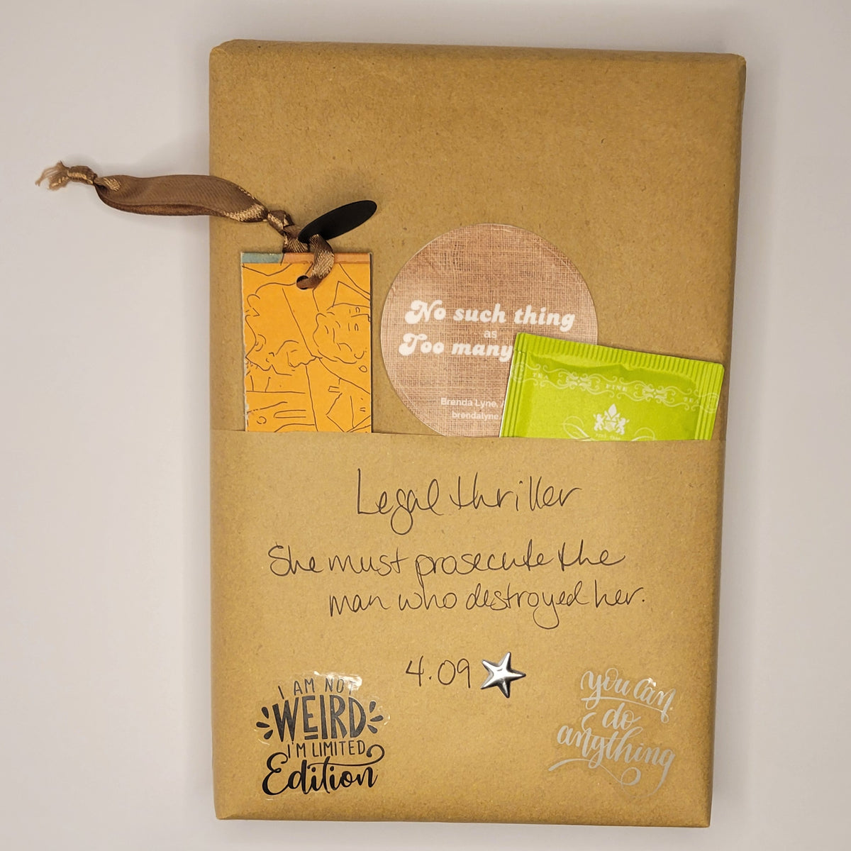 Hardcover book wrapped in brown paper with writing on it and goodies tucked inside.