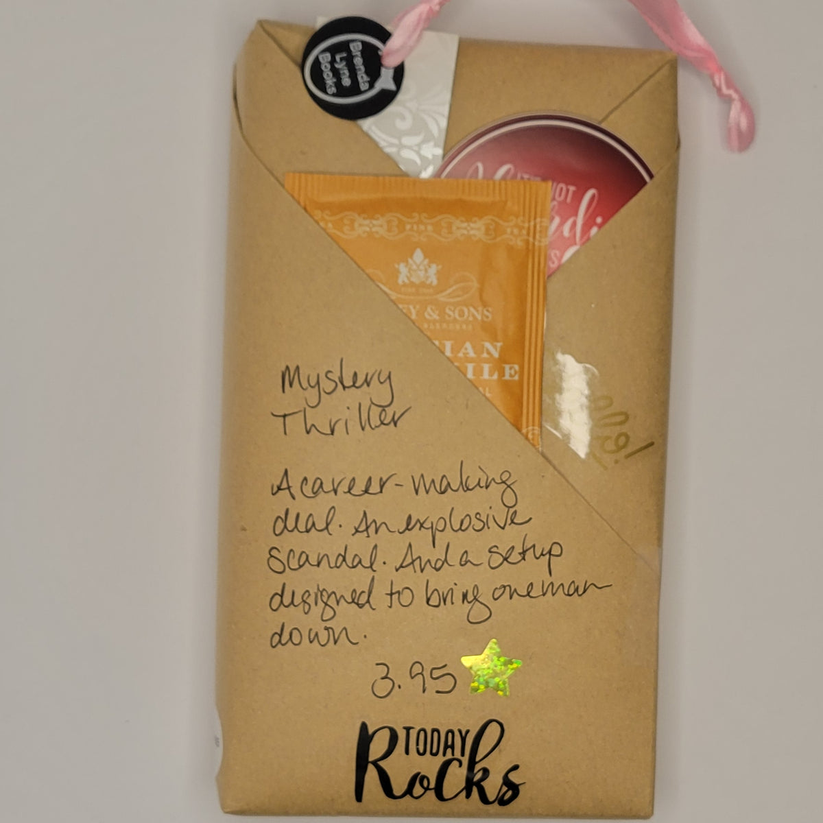 Paperback book wrapped in brown paper with writing on it and goodies tucked inside.