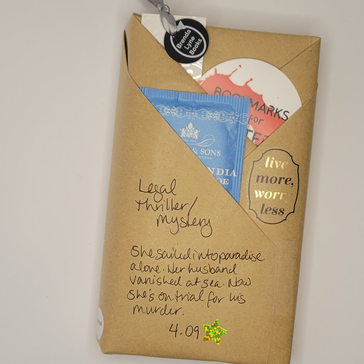 Paperback book wrapped in brown paper with writing on it and goodies tucked inside.
