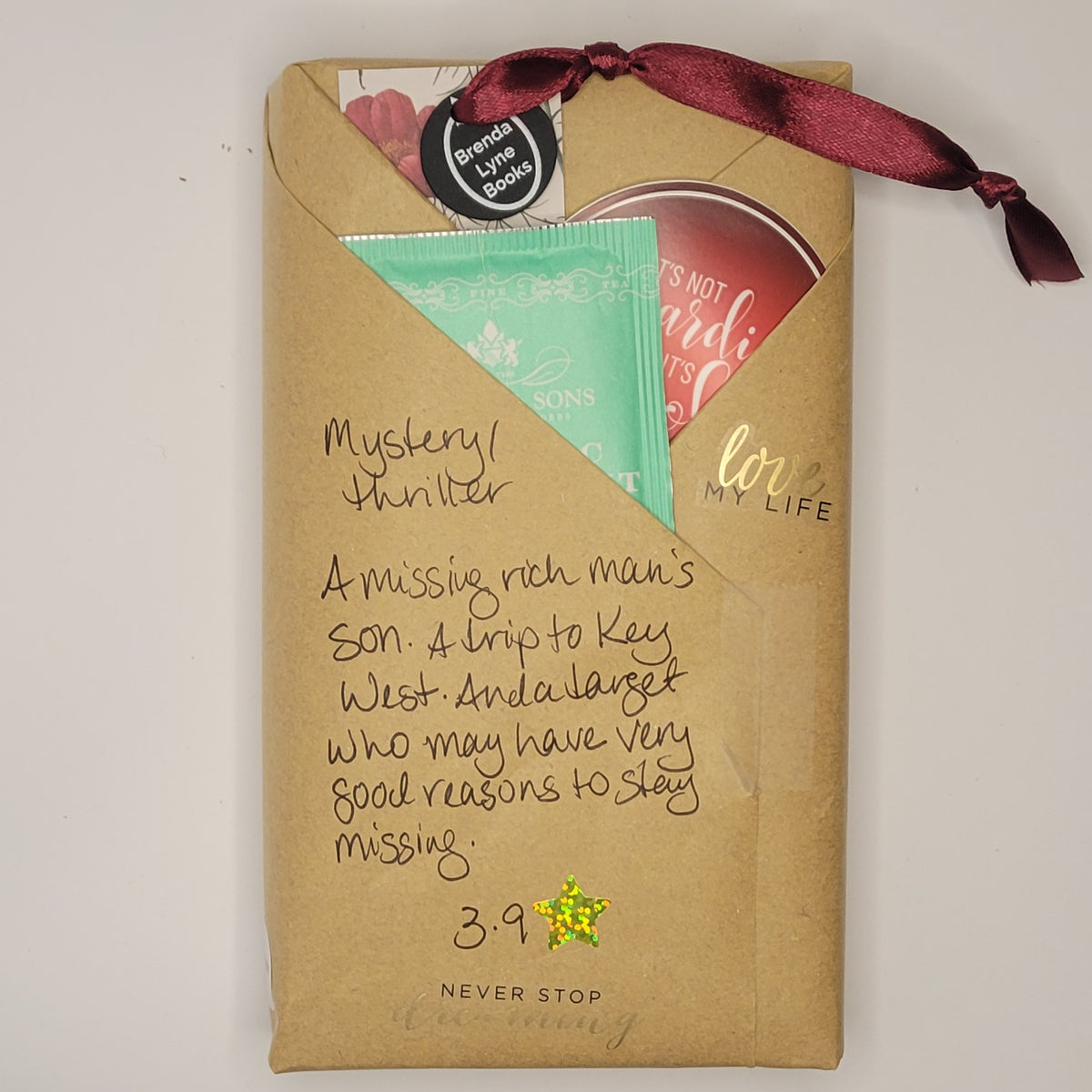 Paperback book wrapped in brown paper with writing on it and goodies tucked inside.