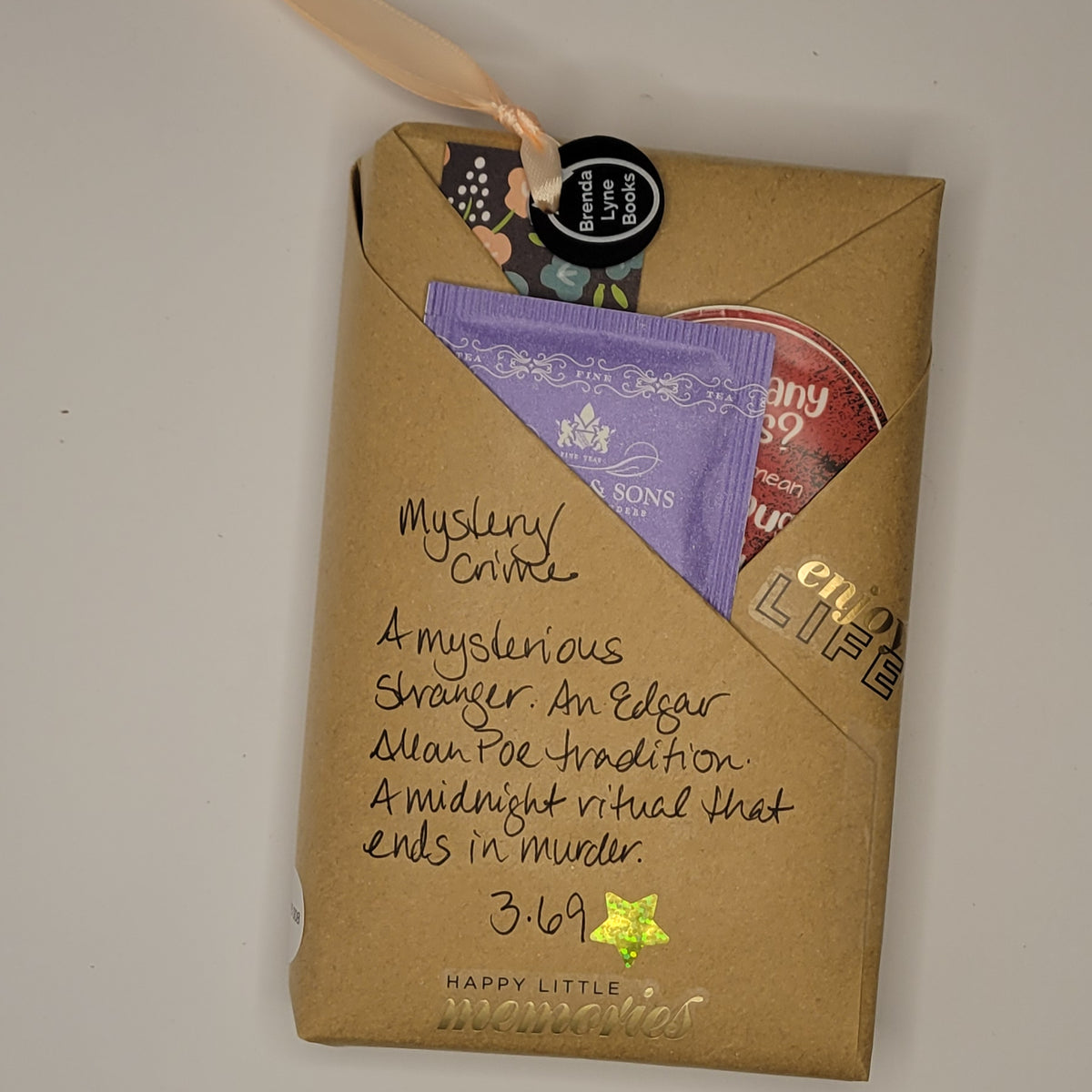 Paperback book wrapped in brown paper with writing on it and goodies tucked inside.