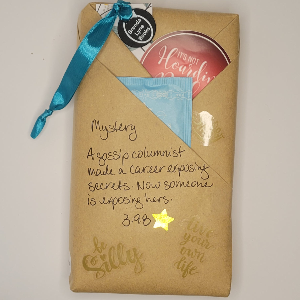 Paperback book wrapped in brown paper with writing on it and goodies tucked inside.