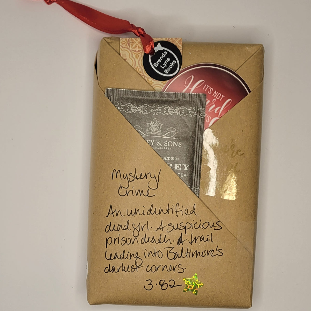 Paperback book wrapped in brown paper with writing on it and goodies tucked inside.