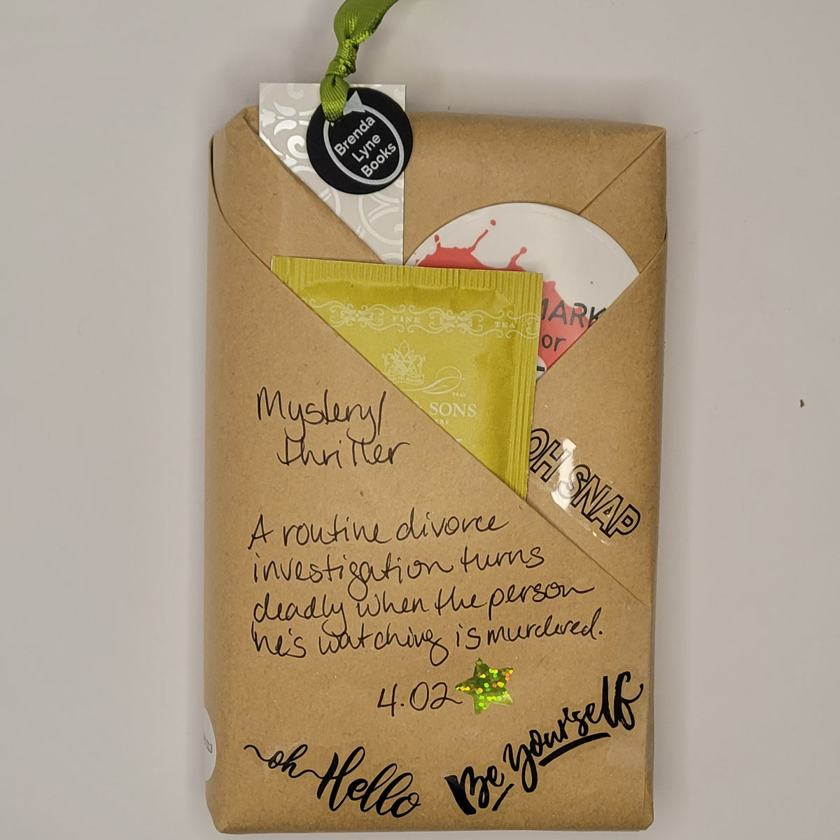 Paperback book wrapped in brown paper with writing on it and goodies tucked inside.
