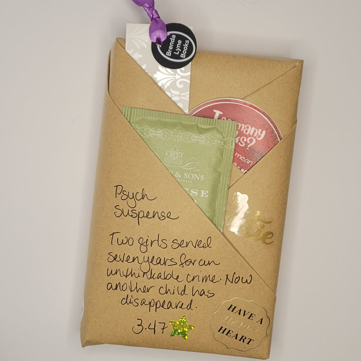 Paperback book wrapped in brown paper with writing on it and goodies tucked inside.