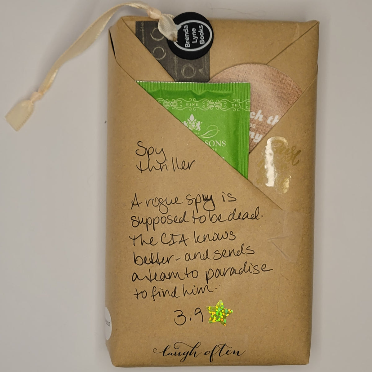 Paperback book wrapped in brown paper with writing on it and goodies tucked inside.