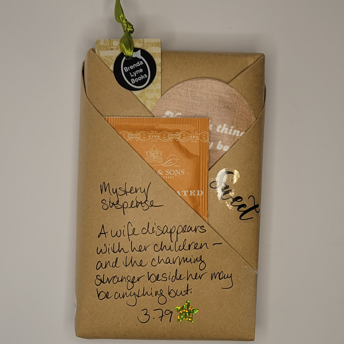 Paperback book wrapped in brown paper with writing on it and goodies tucked inside.